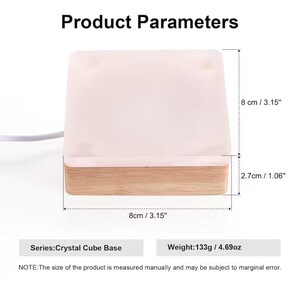 May include: A white crystal cube base with a wooden frame. The base measures 8 inches by 8 inches and is 2.7 inches tall. It weighs 4.69 ounces. The text "Series: Crystal Cube Base" and "Weight: 133g / 4.69oz" is printed below the image. The text "NOTE: The size of the product is measured manually and may be subject to marginal error." is printed below the text.