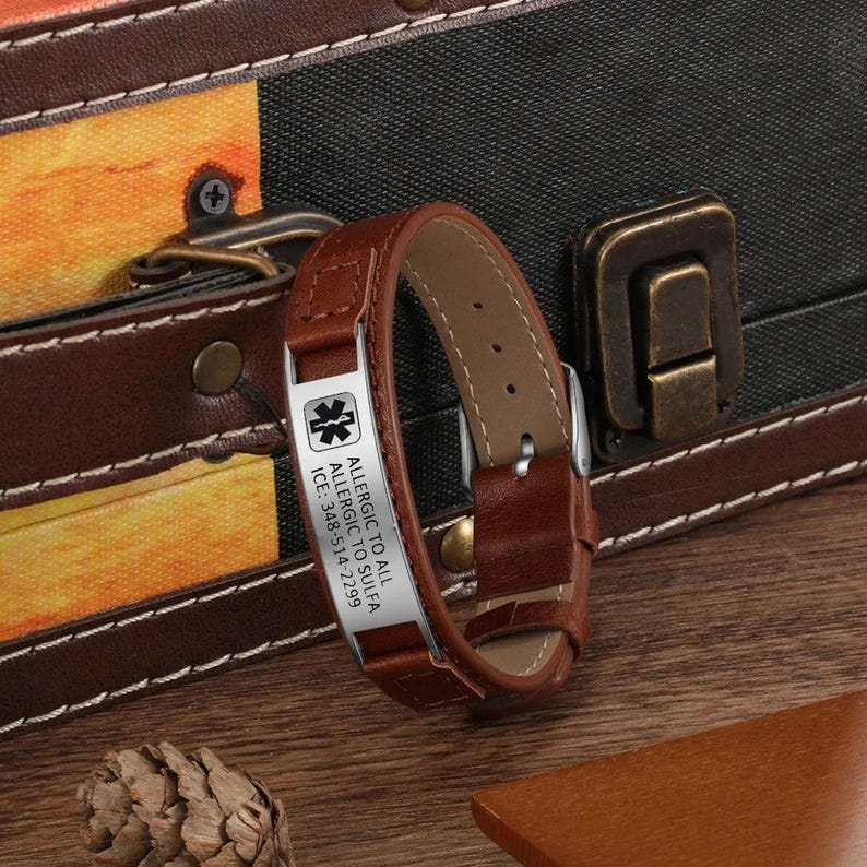 Puede incluir: Pulsera de alerta m&eacute;dica de cuero marr&oacute;n con una placa plateada grabada con el texto "Allergic to All Allergic to Sulfa ICE: 348-514-2229" y un s&iacute;mbolo m&eacute;dico.