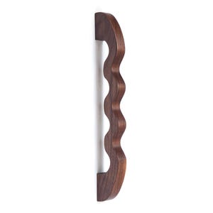 May include: A dark brown wooden cabinet door handle with a wavy design.