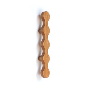 May include: A wooden cabinet knob with a wavy design. The knob is brown and has a smooth finish.