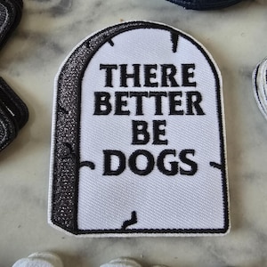 Peut inclure: Patch brodé blanc en forme de pierre tombale avec une bordure noire. Le texte sur le patch est "There better be dogs."