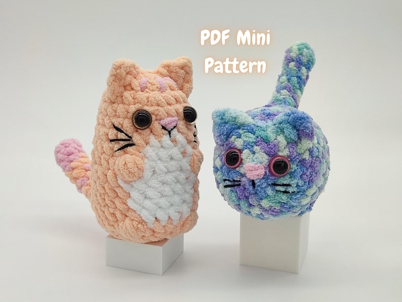 Two plush amigurumi mini kittens - one orange, the other blue/purple - made from this kitten crochet pattern. A note states that the listing is for a PDF pattern only.