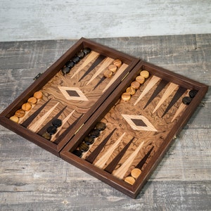May include: A wooden backgammon game board with a dark brown finish and a diamond inlay. The board is open and shows the playing surface with black and brown checkers.