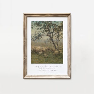 May include: A framed print with a painting of a flock of sheep grazing in a field with a tree in the background. The print includes the text "my sheep hear my voice, and I know them, and they follow me. John 10:27"