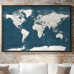 Peut inclure: Une carte du monde encadrée avec un océan bleu foncé et des masses terrestres blanches. La carte est détaillée avec les noms et les frontières des pays, sur un fond bleu foncé. Le cadre est noir, et la carte est accrochée à un mur de briques.