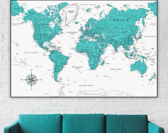 May include: A teal blue world map with black outlines and white text. The map is framed and hanging on a white brick wall above a teal blue couch.