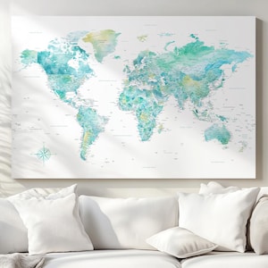 Può includere: Una stampa artistica rettangolare da parete che raffigura una mappa del mondo con continenti in stile acquerello nei toni del verde acqua, turchese e verde chiaro su sfondo bianco. La mappa include etichette dei paesi e una rosa dei venti.