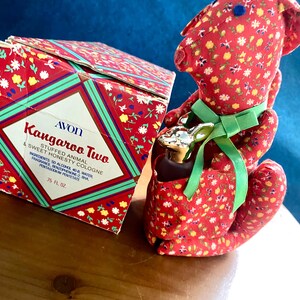 May include: A vintage Avon Kangaroo Two cologne set. The box and stuffed animal kangaroo are red with a floral pattern. The box has green and white accents and the text "Kangaroo Two & Sweet Honesty Cologne". The bottle is 2218 ml.