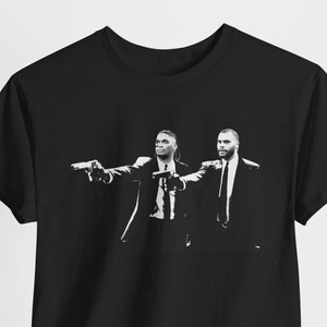 May include: Black t-shirt with a white graphic print of two men in suits pointing guns.