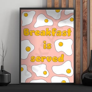 May include: A pink background with white eggs with yellow yolks and the text "Breakfast is served" in yellow letters.
