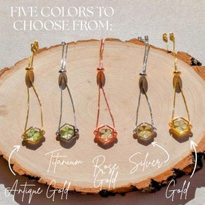 May include: Five adjustable bracelets with a four-leaf clover encased in a hexagon-shaped pendant. The bracelets are available in antique gold, titanium, rose gold, silver, and gold.