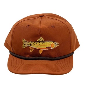 May include: A brown baseball cap with a brown brim and a brown and yellow embroidered trout on the front.