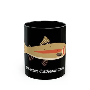 May include: Black ceramic mug with a graphic of a Lahontan Cutthroat Trout. The fish is illustrated in shades of brown, orange, and yellow against a black background.