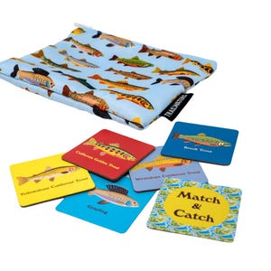 May include: A set of six colorful square cards with images of different types of trout and the words "Match & Catch" on one card. The cards are in a blue drawstring bag with a pattern of trout.