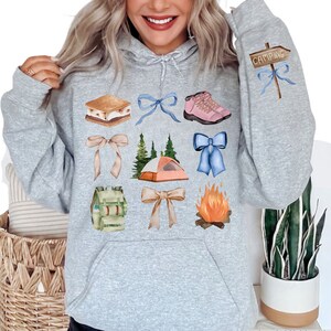 a woman wearing a hoodie with a bunch of things on it
