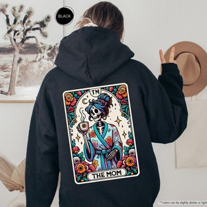 a person wearing a black hoodie with a picture of a skeleton on it