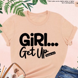 a t - shirt that says girl get up next to a purse