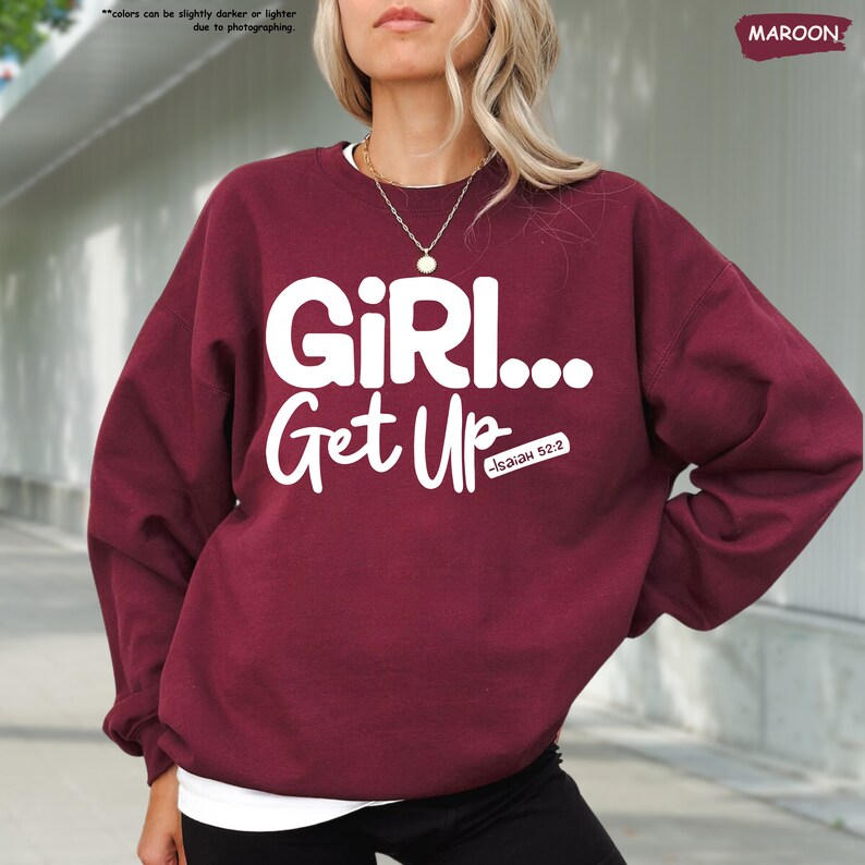 a woman wearing a maroon sweatshirt that says girl get up