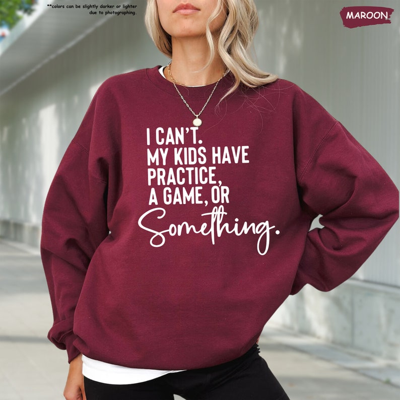 a woman wearing a sweatshirt that says i can't my kids have practice,