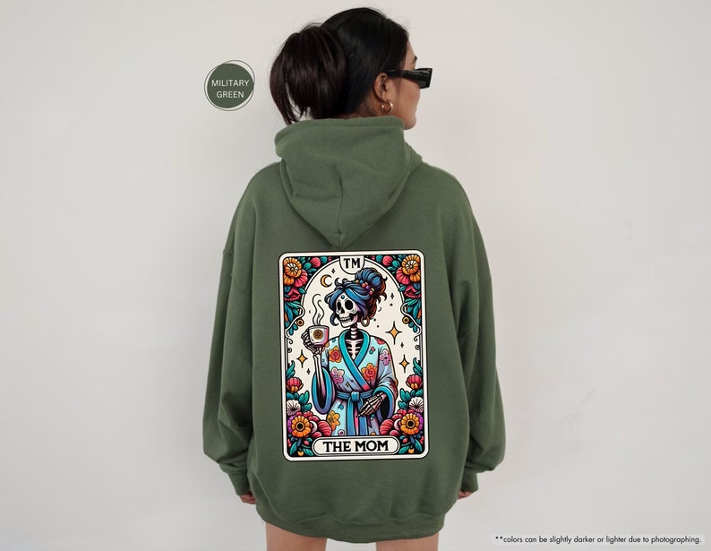 a woman wearing a green hoodie with a picture of a skeleton on it