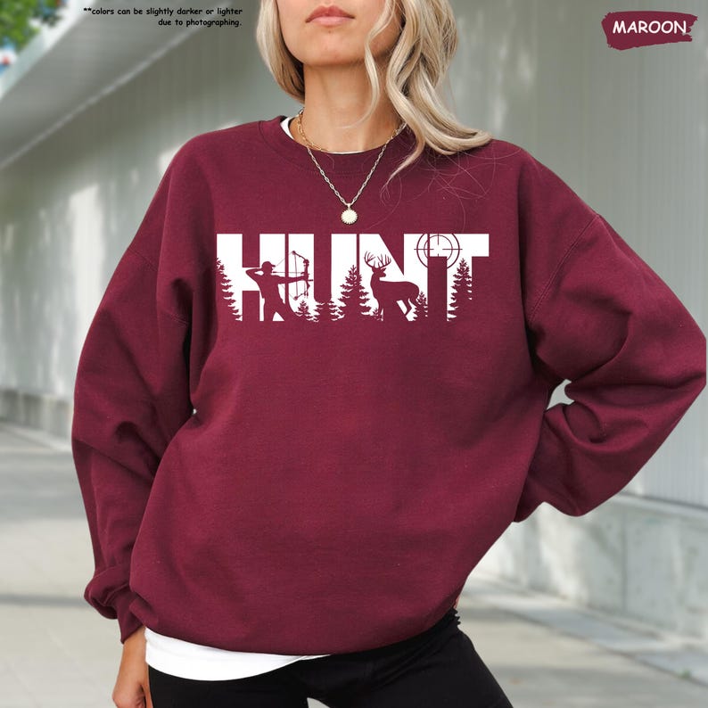 a woman with blonde hair wearing a maroon sweatshirt and black pants