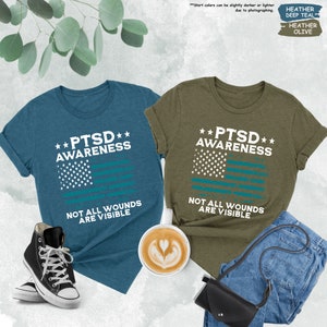 a couple of t - shirts that are next to a cup of coffee