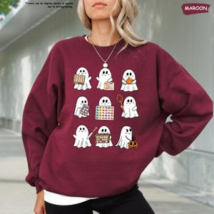 a woman wearing a sweater with ghost pictures on it