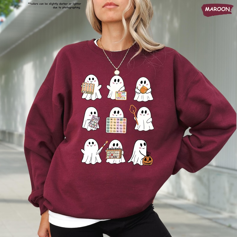 a woman wearing a sweater with ghost pictures on it