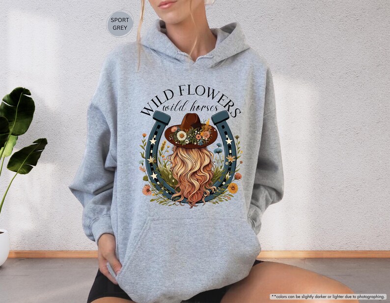 May include: Gray hooded sweatshirt with the text "WILD FLOWERS wild horses" and a graphic of a woman wearing a cowboy hat and a horseshoe.