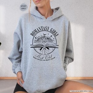 May include: A grey hooded sweatshirt with a black graphic design that says "Romantasy Girl" and "Book Club" with a book, flowers, and birds.