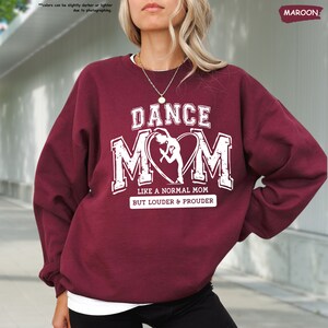 a woman wearing a sweatshirt that says dance mom