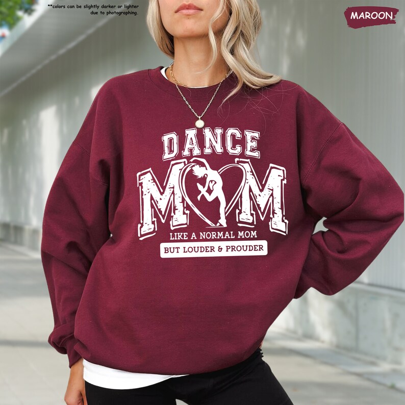 a woman wearing a sweatshirt that says dance mom