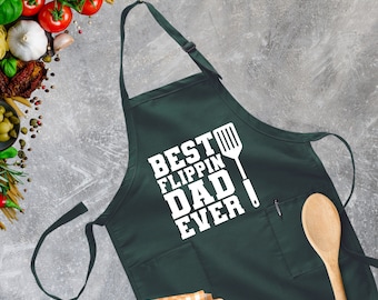 May include: A dark green apron with a white graphic that says "Best Flipping Dad Ever" and a spatula icon.