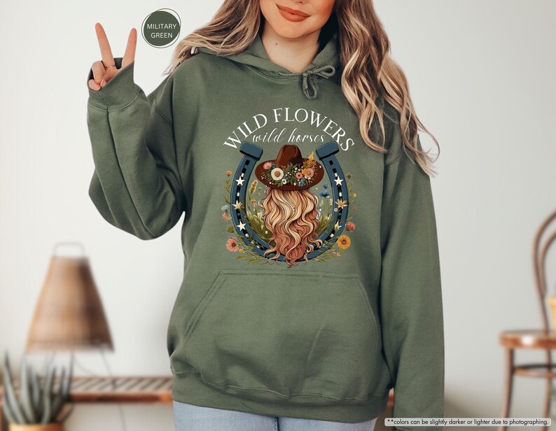 May include: A green hooded sweatshirt with the text "WILD FLOWERS wild horses" and a graphic of a woman with a flower crown and a horseshoe.