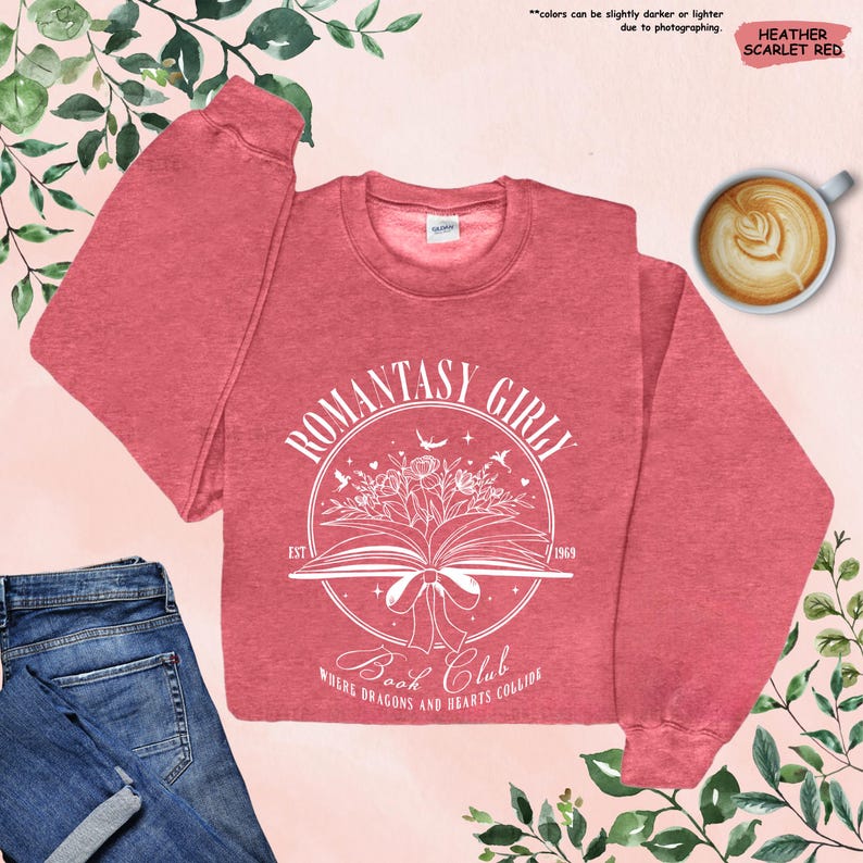 May include: A heather scarlet red sweatshirt with a white graphic design of an open book with flowers and birds. The text "ROMANTASY GIRLY" is in a circle around the book. The text "EST 1969" is below the book. The text "Book Club" is below the circle. The text "WHERE DRAGONS AND HEARTS COLLIDE" is below the text "Book Club".