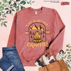 a red sweatshirt with a campfire graphic on it