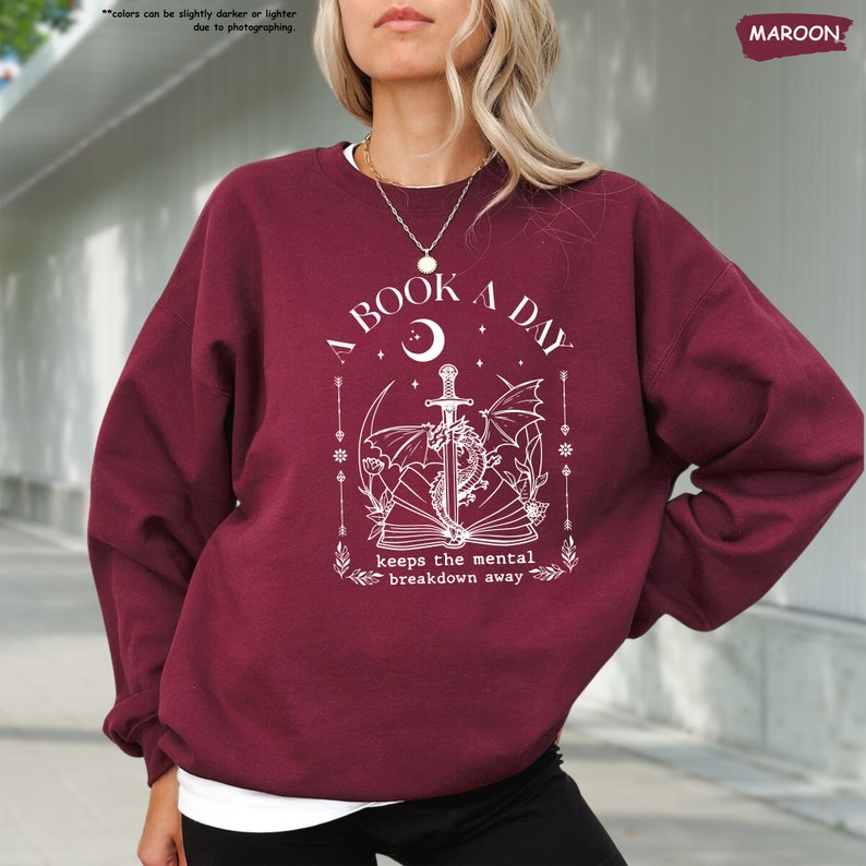 a woman wearing a maroon sweatshirt and black pants