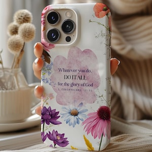 May include: White iPhone case with a floral design and the quote "Whatever you do, do it all for the glory of God, 1 Corinthians 10:31".