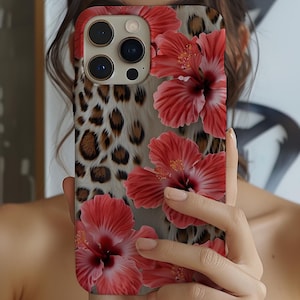May include: A phone case with a leopard print and pink hibiscus flowers. The case is made of a hard plastic material and has a glossy finish.