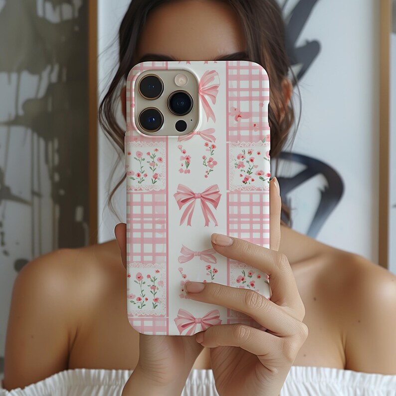 May include: A white phone case with a pink and white checkered pattern, pink bows, and pink flowers.