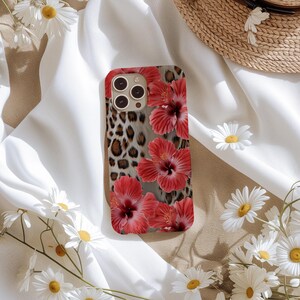 May include: A phone case with a leopard print and red hibiscus flowers. The case is designed for an iPhone.