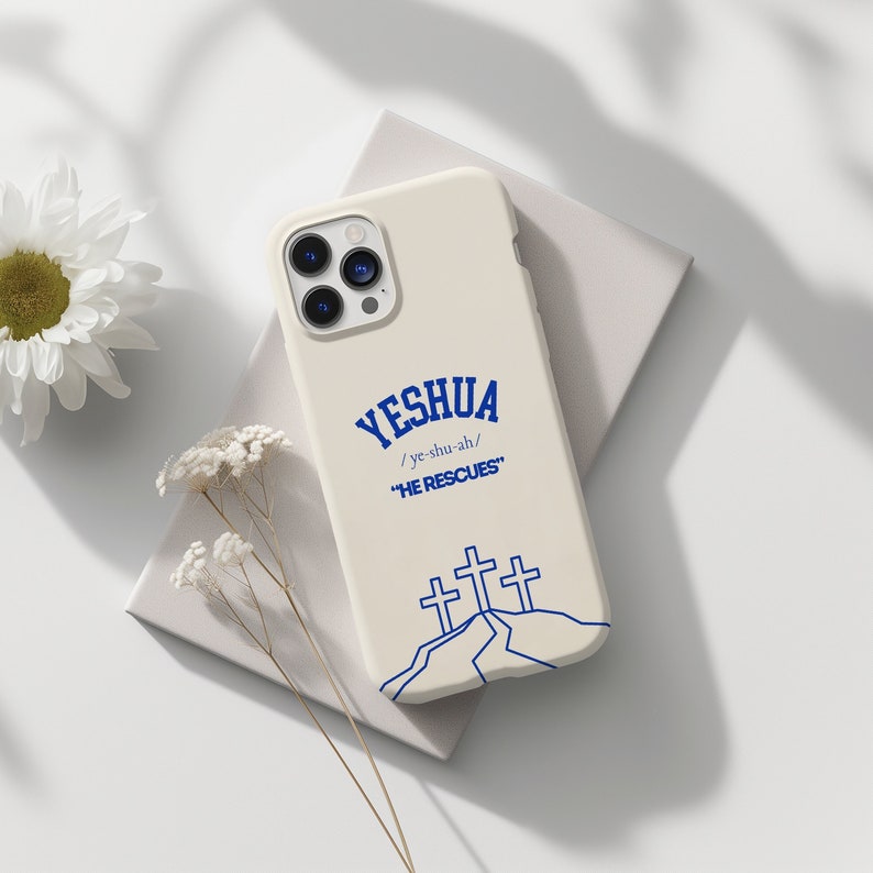May include: A white iPhone case with a blue design featuring the word "Yeshua" with the phonetic spelling "/ye-shu-ah/" and the phrase "He Rescues". Three blue crosses are depicted on a white hill.