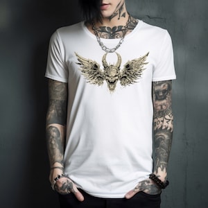Puede incluir: Camiseta blanca con un estampado gráfico de una calavera con alas. La calavera es beige y las alas son de un beige más claro. La calavera tiene cuernos y una expresión amenazante.