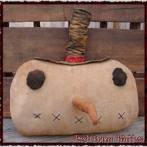 Puede incluir: Una almohada de muñeco de nieve primitiva hecha a mano con un sombrero de tela marrón, ojos de fieltro negro, una nariz de fieltro marrón y una sonrisa cosida. La almohada está hecha de tela de arpillera y tiene un aspecto rústico y vintage.