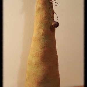 May include: A handmade primitive Christmas tree with a star on top and a bell hanging from a wire. The tree is made of fabric and has a brown base with the text "Peach Bottom Primitives" stitched on it.