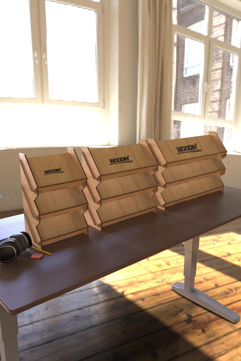 May include: Four wooden display stands with three shelves each. The stands are made of light brown wood and have the word "WOODIN" printed on the top shelf. The stands are arranged in a row on a brown table.