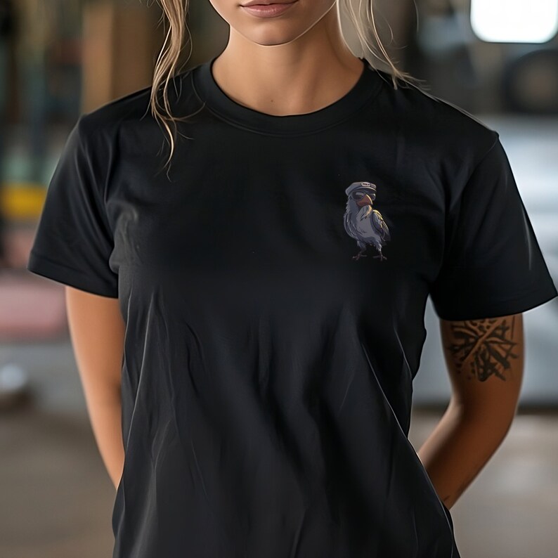 以下が含まれることがあります： 船乗り帽をかぶった鳥のグラフィックがプリントされた黒いTシャツ