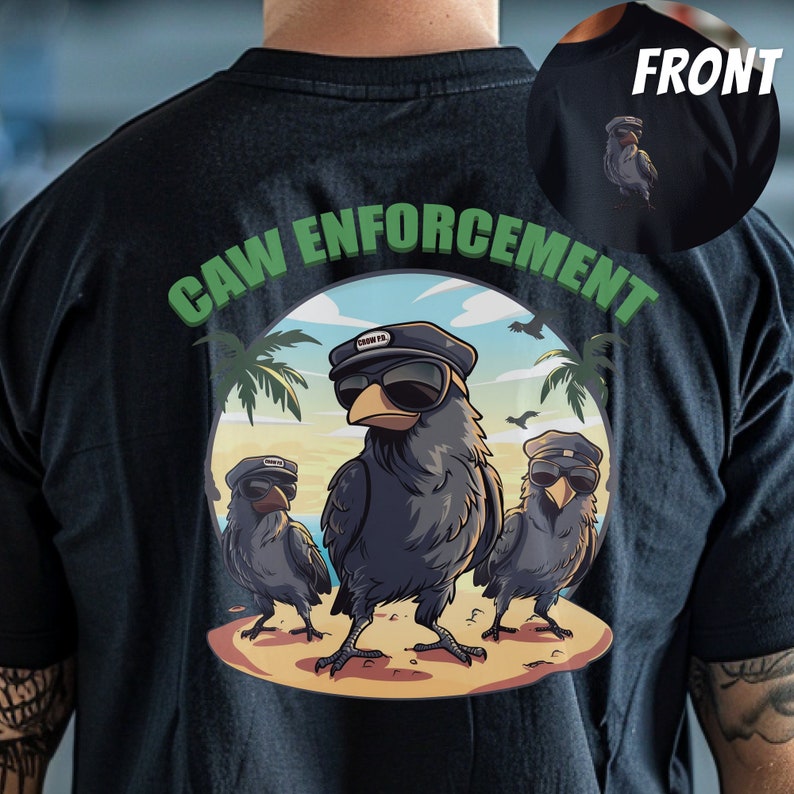 以下が含まれることがあります： 黒いTシャツに、サングラスと帽子をかぶったカラス3羽のグラフィックがプリントされています。カラスの上に緑色の文字で「CAW ENFORCEMENT」と書いてあります。