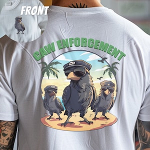 以下が含まれることがあります： 緑色の円形のグラフィックが描かれた白いTシャツ。グラフィックには、サングラスと帽子をかぶった3羽の漫画の鳥が描かれています。円周には「CAW ENFORCEMENT」という文字が書かれています。