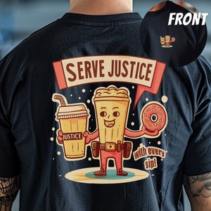 Puede incluir: Una camiseta negra con una ilustración de dibujos animados de un personaje de taza de café que sostiene una dona y una taza de café. El texto "Serve Justice with every sip!" está impreso en la camiseta.